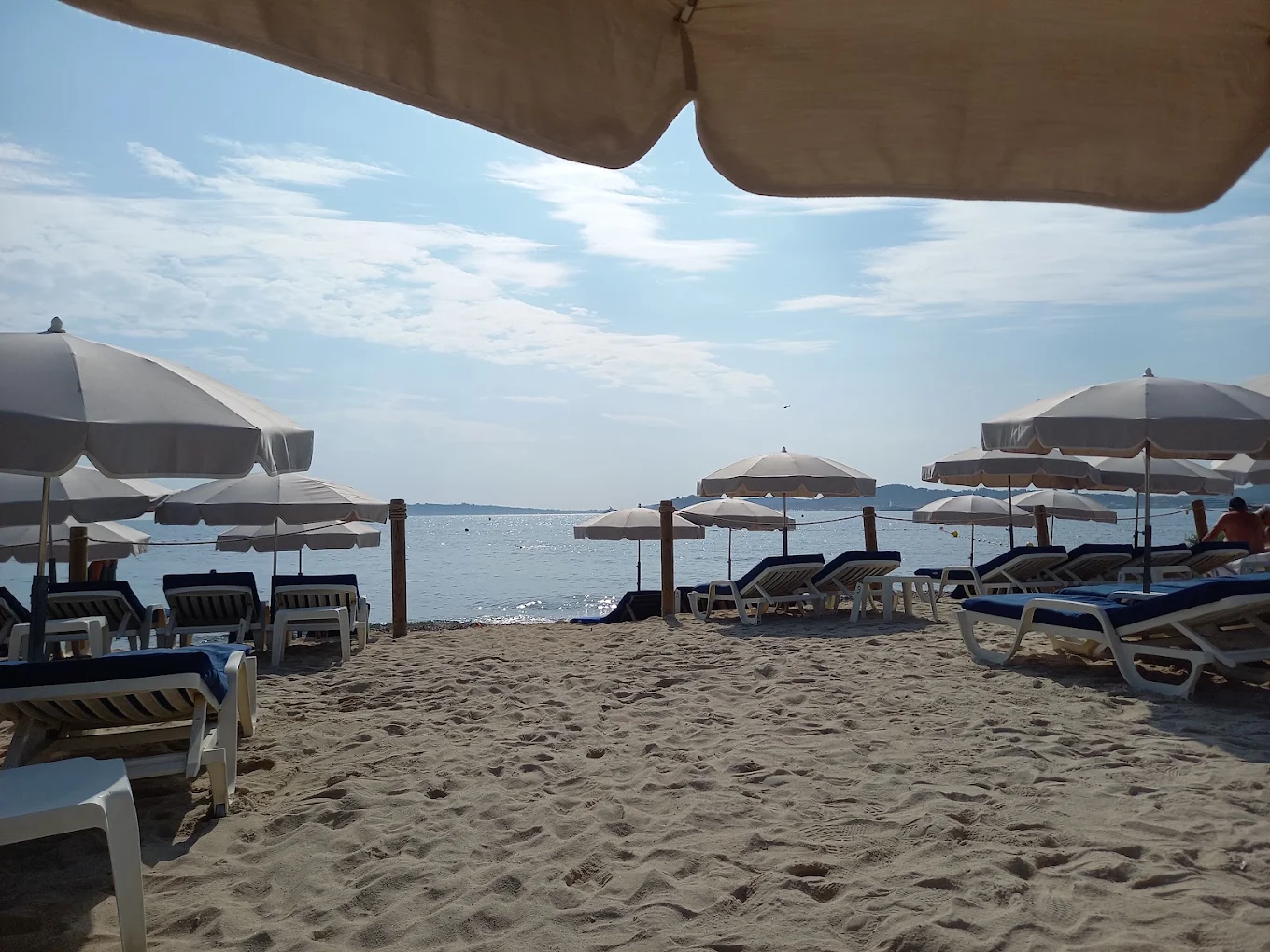 Transats bleus et parasols sur le sable chaud